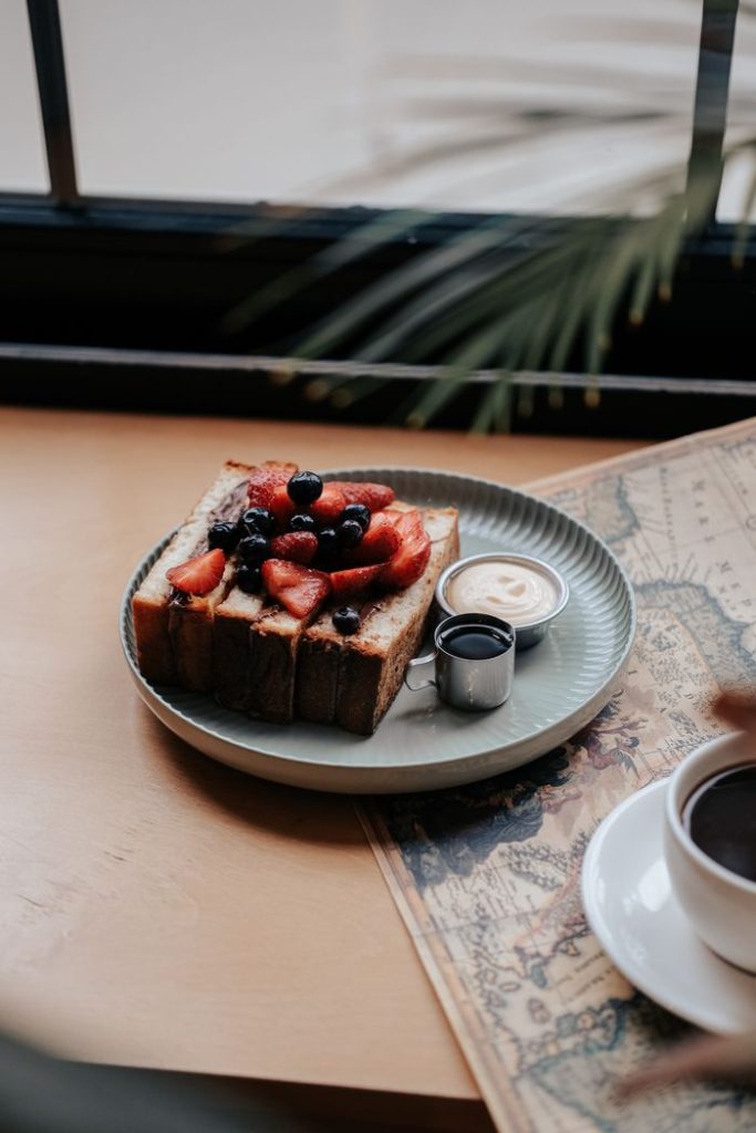 A cozy cafe setting with fresh berry toast and a cup of coffee. Perfect for brunch ideas.